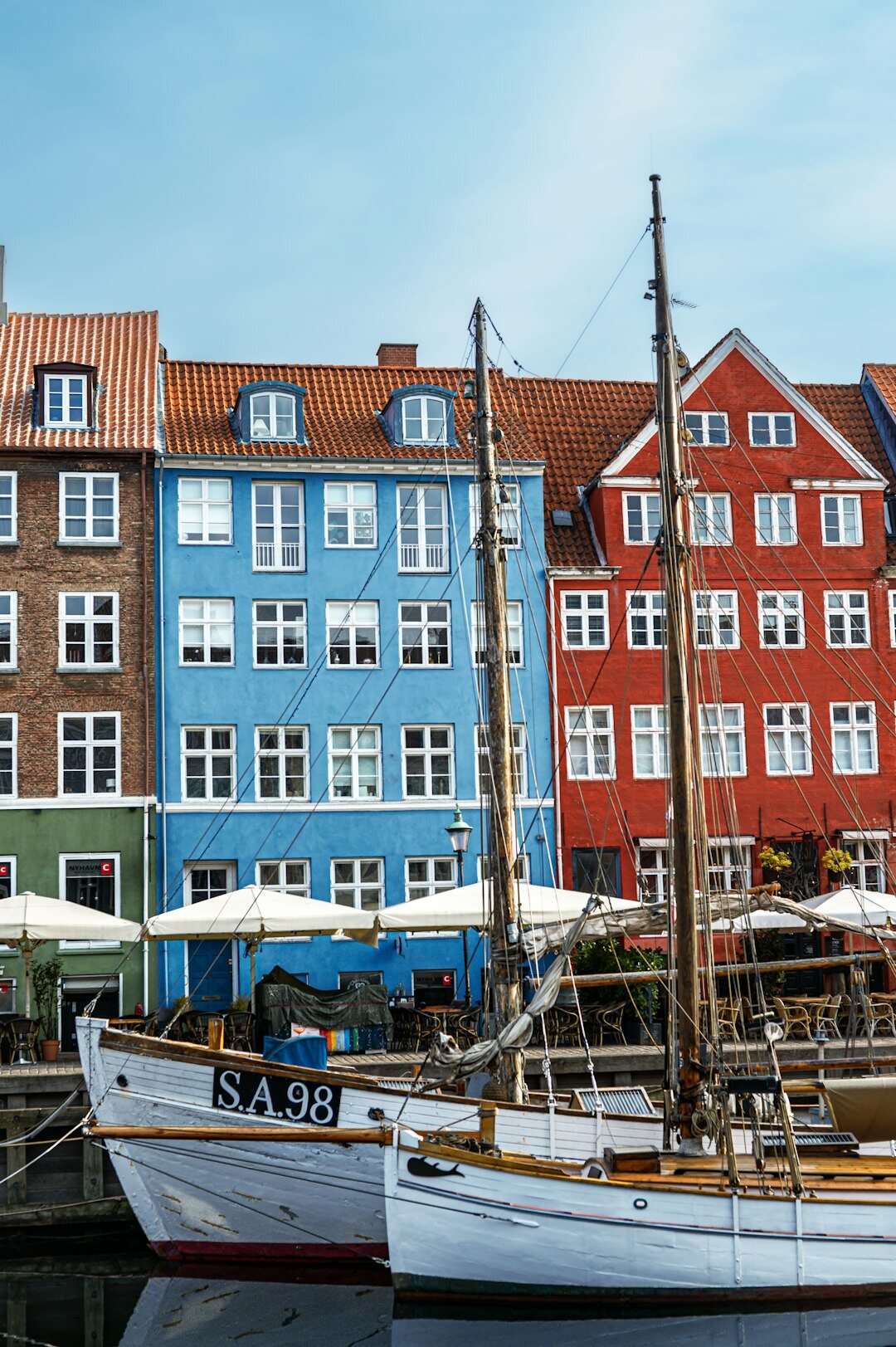 Elderly Danish fisherman standing near harbor boats
